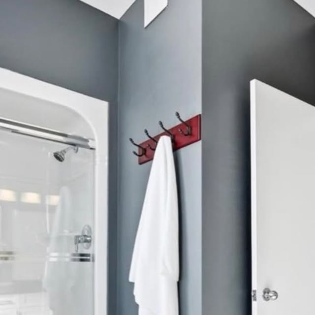 Bathroom after a focused floor refresh with deep grey walls, a white shower, and a red wood hook rail