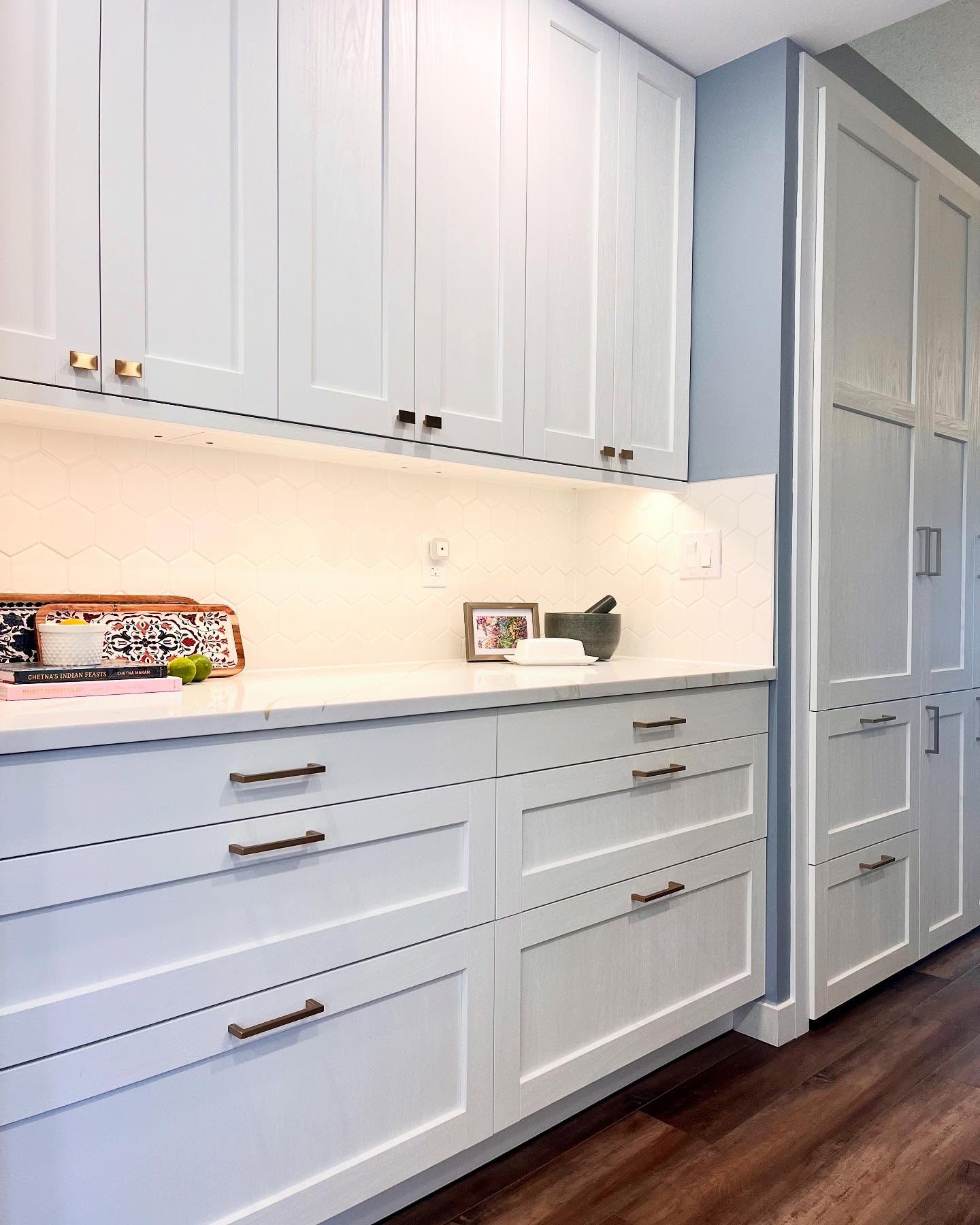 Finished Project Daisy pantry run with tall white shaker cabinets, hexagon tile, and under-cabinet lighting