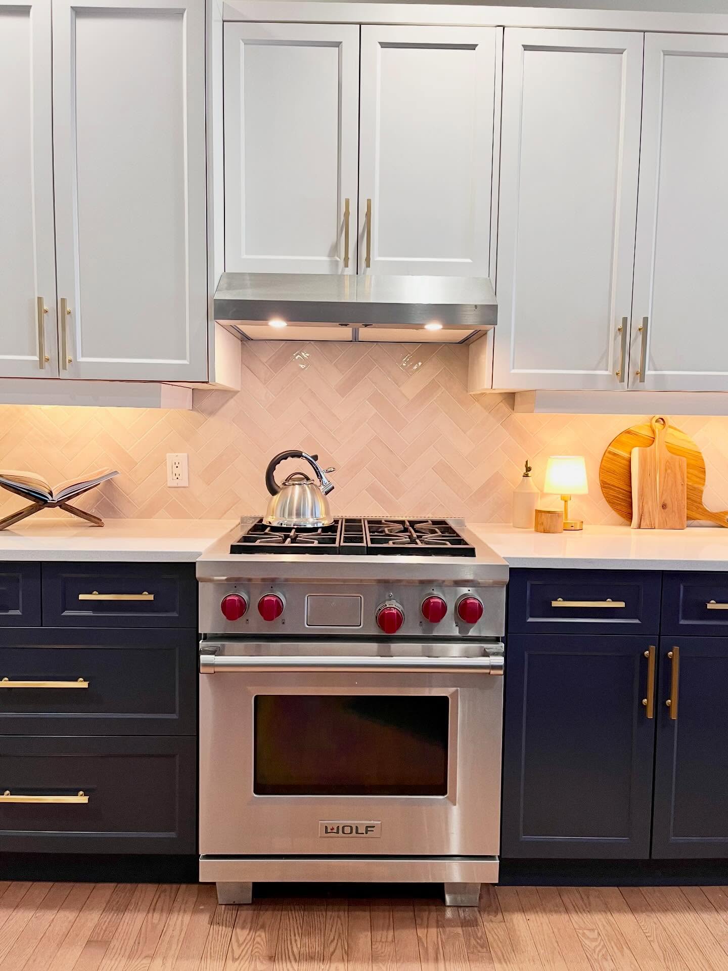 Head-on finished view of the Project Lily Wolf range with cream herringbone tile and two-tone cabinets