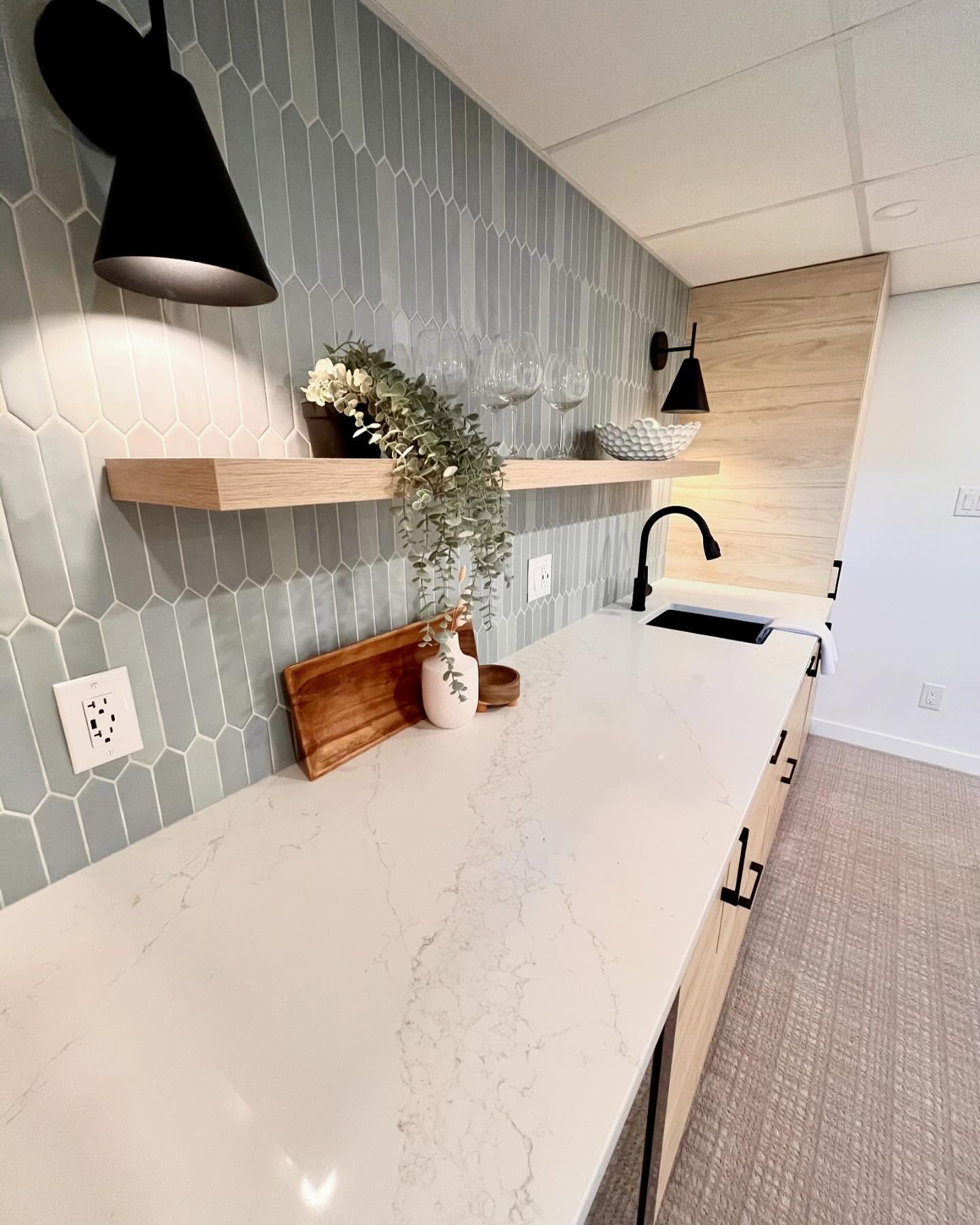 White veined wet bar counter, matte black faucet, and sage picket tile