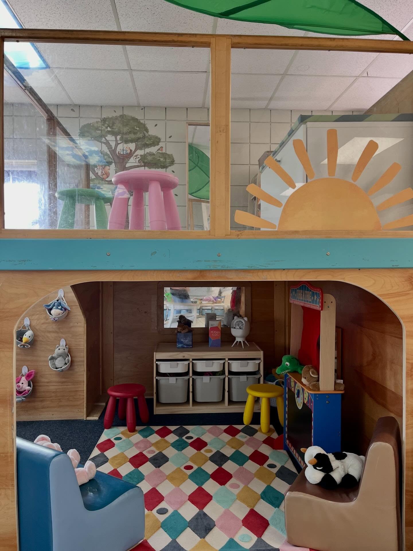 Finished daycare rooms: a two-storey play loft with storage bins and wood framing
