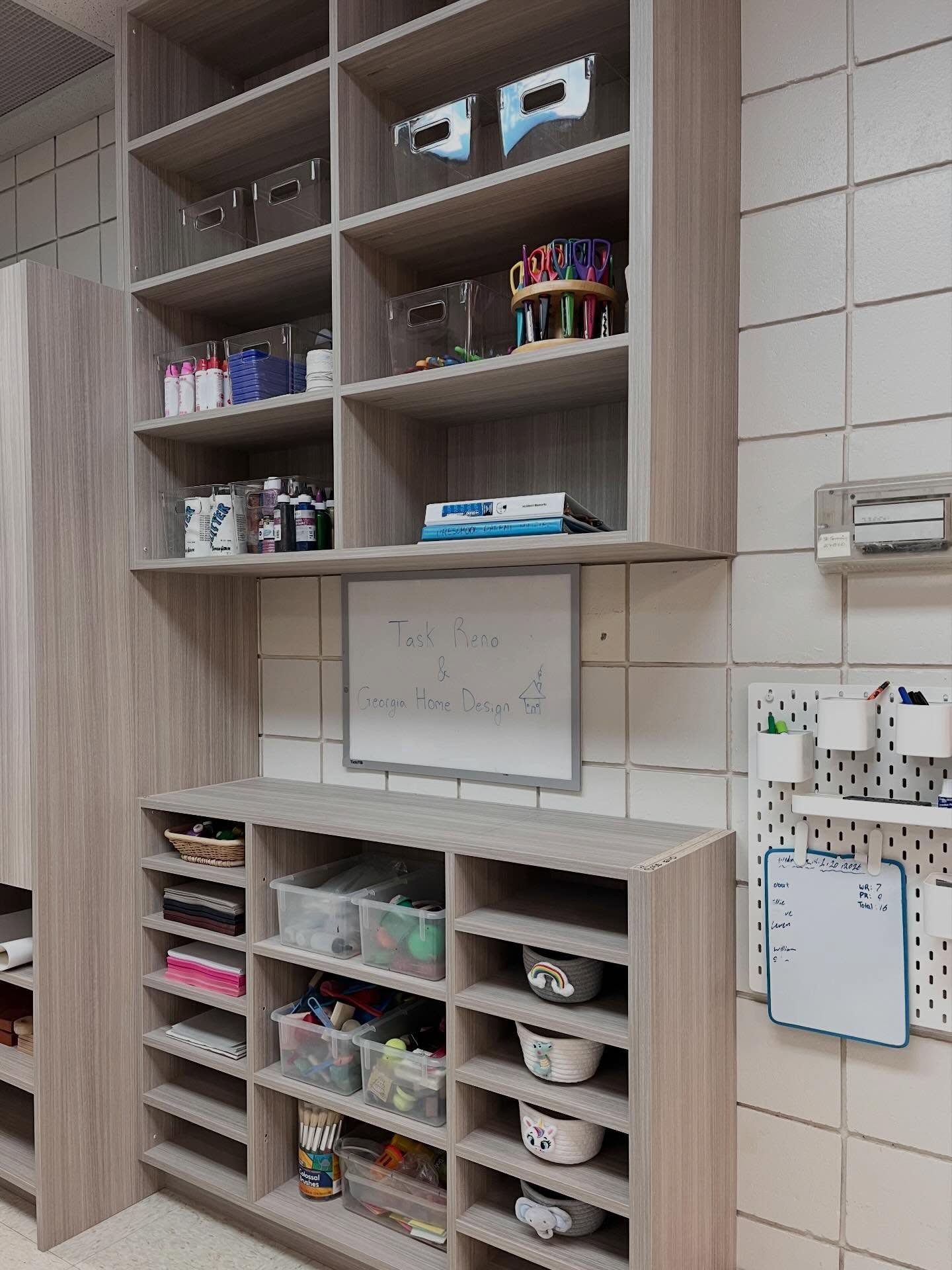 Finished daycare storage cabinets with craft bins, paper slots, woven baskets, and a whiteboard on a tiled wall