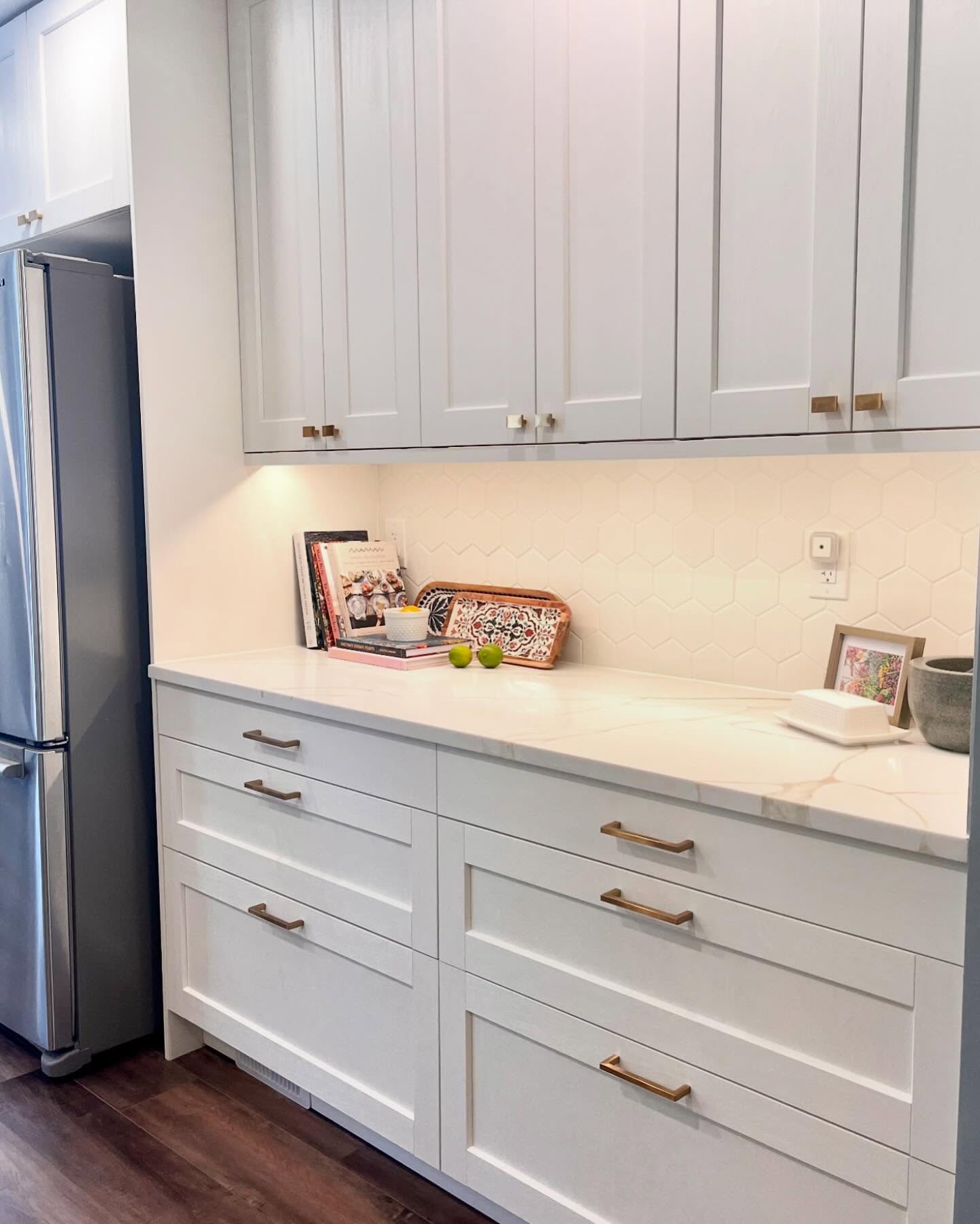 Project Daisy pantry run with white shaker cabinets, brass hardware, white hexagon tile, and generous drawers