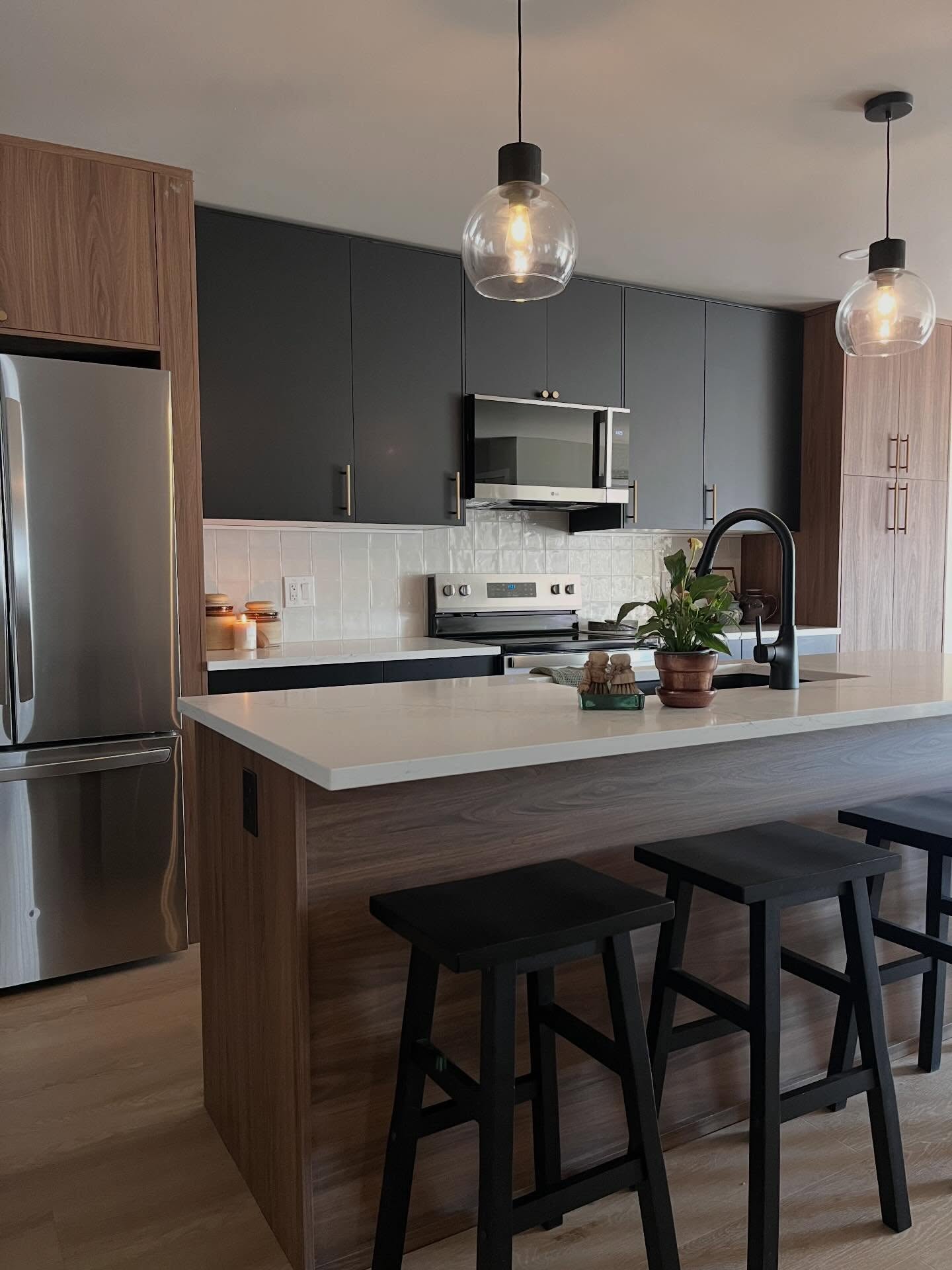 Kitchen after: wood-base island, white quartz, charcoal uppers