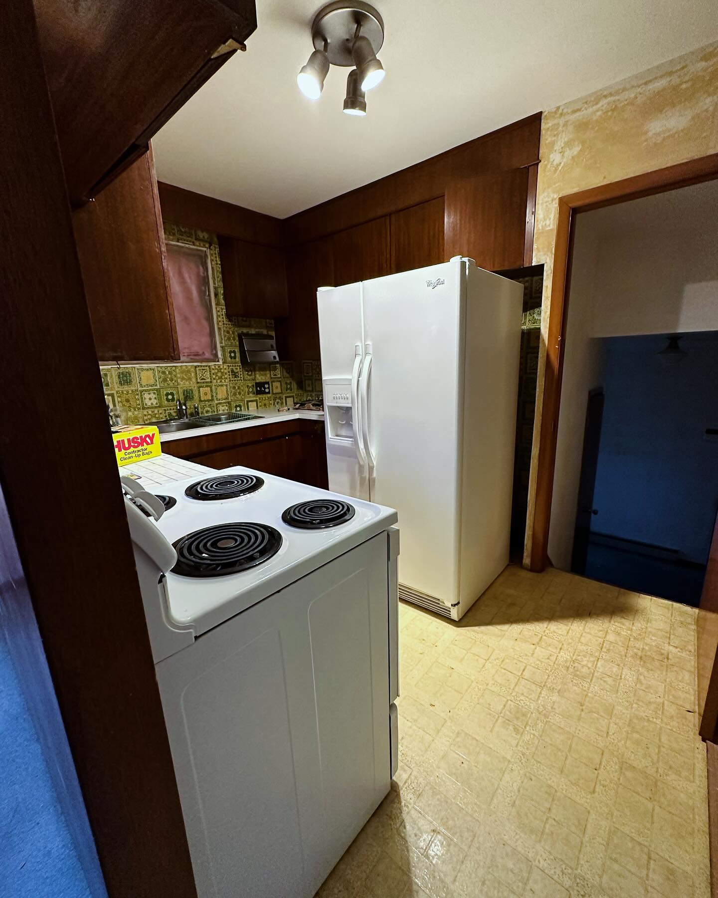 Project Rose kitchen before the renovation, with dark wood cabinets and green patterned tile
